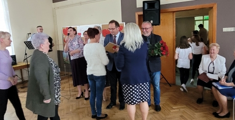 Wójt Gminy Roman Boguś oraz Radny Andrzej Danielczak wręczają dyplomy i kwiaty mamom