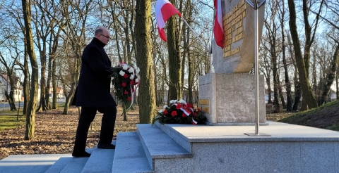 Przewodniczący Rady Gminy Duszniki składa wiązankę kwiatów pod pomnikiem. 