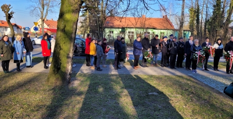 Delegacje pracowników samorządu i mieszkańców gminy z wiązankami biało-czerwonych kwiatów.