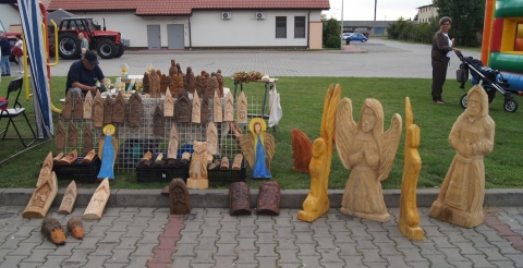 Drewniane rzeźby na stoisku z rękodziełem na placu przy bibliotece w Dusznikach podczas Dożynek Gminnych 2021.