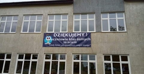Na zdjęciu ściana szkoły z banerem z podziękowaniami uczniów klas ósmych ze Szkoły Podstawowej w Dusznikach