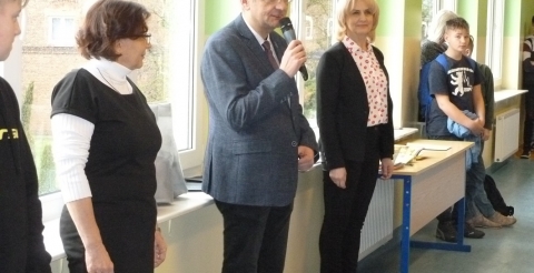 Na zdjęciu Wójt Gminy Duszniki przemawia do uczestników apelu i  wyróżnionych uczniów szkoły. Towarzyszą mu dyrektor i wicedyrektor szkoły.